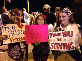 Stacy and Christy offer hugs to veterans at an Honor Flight.